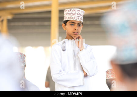 Nizwa, Oman - 23 Mar 2018: giovane premuroso Omani boy in bianco tradizionali Omani abito - kandura. Foto Stock