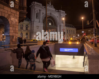 BUDAPEST, Ungheria - 6 Aprile 2018: Famiglia andando giù per le scale di una stazione della metropolitana di fronte a Budapest Keleti palyaudvar stazione ferroviaria di notte Pict Foto Stock
