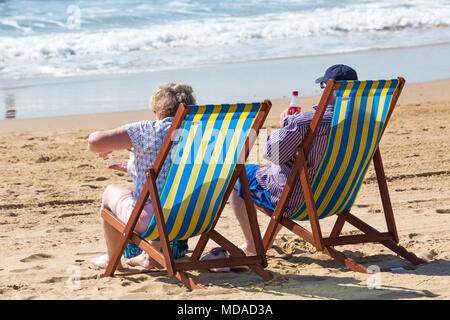 Bournemouth Dorset, Regno Unito. Il 19 aprile 2018. Regno Unito: meteo bella calda giornata di sole a Bournemouth spiagge con cielo azzurro e sole ininterrotta, come i visitatori in testa al mare per godere il giorno più caldo dell'anno finora. Coppia matura in rilassanti sedie a sdraio sulla spiaggia. Credito: Carolyn Jenkins/Alamy Live News Foto Stock