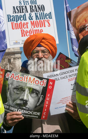 Londra, Regno Unito. Il 18 aprile 2018. Un Sikh contiene fino manifesti che chiedono giustizia per il 1984 genocidio Sikh, con modi descritti come #AdolfModi. Kashmiris e Indiani provenienti da molte parti della Comunità, compreso il tamil, sikh, Ravidass, dalit, musulmani e altri in piazza del parlamento in segno di protesta contro il Primo Ministro Narendra Modi che dicono è perseguire politiche dettate dall'ultra-lotta supremazia indù RSS. Essi vogliono un termine per il suo incoraggiamento di mob violenza contro altre comunità religiose, in particolare i musulmani e i cristiani, alla sua protezione di stupratori, alla promozione di casta hier Foto Stock