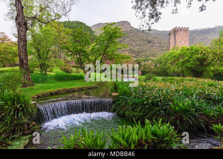 Il Giardino di Ninfa, Italia - un monumento naturale con rovine medievali in pietra, parco di fiori e un fantastico il torrente con poca caduta. Provincia di Latina. Foto Stock