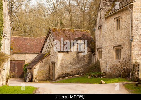 Tradizionale del Cotswold casale in pietra con paese lane avvolgimento attraverso di esso nel Cotswold il villaggio di Bibury nella contea inglese Gloucestershire Foto Stock