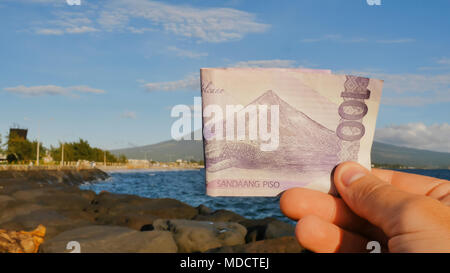 Philippine denaro. Un filippino nota monetaria in un centinaio di pesos è dedicata al vulcano Mayon. Foto Stock