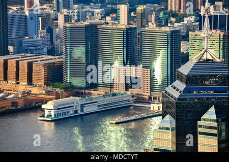 Tramonto, Tsim Sha Tsui Hong Kong. Oro riflette la luce del sole fuori le finestre di vetro della città di grattacieli. Bella citiscape con tetto viste dall'alto. Foto Stock