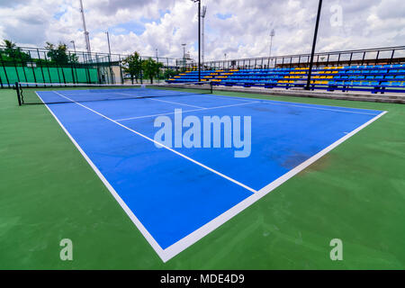 Blue campo da tennis con linee. Nuvole cielo blu sullo sfondo. Foto Stock