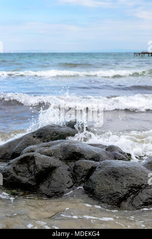 Le onde del mare linea gioco rock di impatto sulla spiaggia Foto Stock