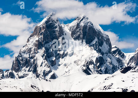 La cima della montagna Ushba, intorno a 4700 m, contro il cielo blu con nuvole bello. Primo piano del famoso doppio picco del Caucaso. Svaneti, Georgia. Foto Stock