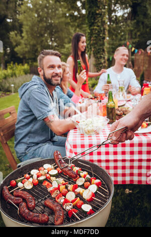Giovane gruppo di amici avente un barbecue party in campagna Foto Stock