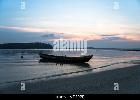 Barca da pesca nel Lago Songkhla al tramonto. Sagome su acqua di mare sullo sfondo. Foto Stock