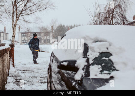 Uomo che pulendo la neve dalla strada, County Kildare, Leinster, Irlanda Foto Stock