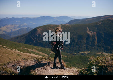 Donna escursionista in piedi in montagna guardando la vista, Ucraina Foto Stock