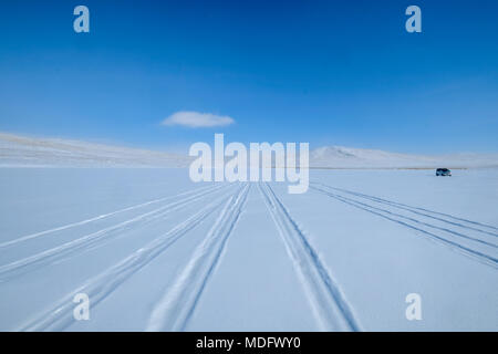 Piste da pneumatici nella neve e un veicolo parcheggiato, Baikal Lake, Irkutsk Oblast, Siberia, Russia Foto Stock