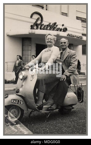 Anni Cinquanta Vintage Butlin ufficiale della vacanza fotografia di un post guerra felice coppia matura a cavallo di una (dell'epoca) trendy Lambretta scooter, con la Butlin's Ocean Hotel dietro, Saltdean East Sussex Regno Unito Foto Stock