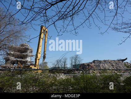 Escavatore da demolizione Caterpillar da 350 L con attrezzatura per frantumatore di calcestruzzo davanti all'edificio in calcestruzzo parzialmente demolito, Bury lancashire uk Foto Stock