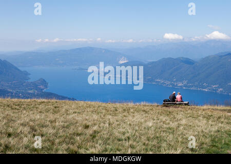 Due turisti che contemplano la splendida vista del Lago maggiore dalla cima del Monte Lema (Monte Lema). Veddasca, Italia Foto Stock
