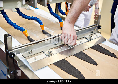 Macchina con tubi per il riempimento di impasto e baker operatore Foto Stock