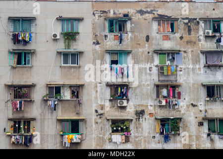 La facciata di un edificio residenziale e stendibiancheria su linee di vestiti appesi da windows in Ho Chi Minh City, Vietnam. Foto Stock