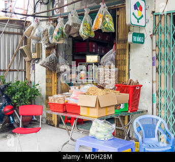 Un piccolo negozio che vende alimenti fritti in scatole e buste in Ho Chi Minh City, Vietnam. Foto Stock