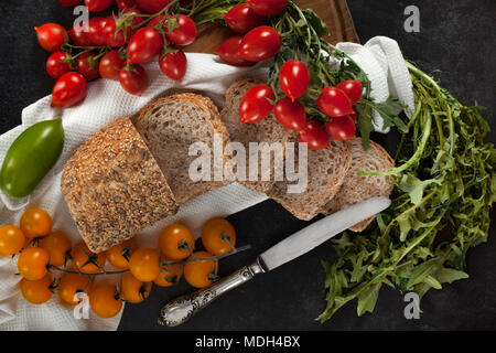 Seminate pane integrale focaccia con vari tipi di pomodori e materie di cicoria. Vista Top Shot. Foto Stock