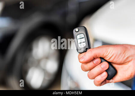 Maschio di mano trattiene chiave auto in auto showroom Foto Stock