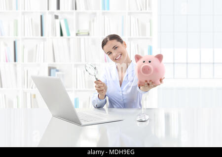 Basso costo e salvataggio di concetto di ricerca, donna sorridente funzionante a scrivania da ufficio su computer con lente di ingrandimento e salvadanaio Foto Stock