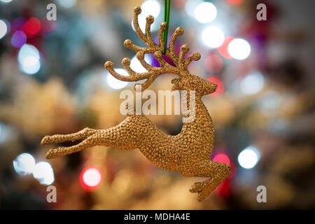 Golden renne nella struttura ad albero di Natale con luci; Londra, Inghilterra Foto Stock