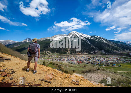 Un anziano uomo escursionismo con vista della montagna di Kendall nella distanza; Silverton, Colorado, Stati Uniti d'America Foto Stock