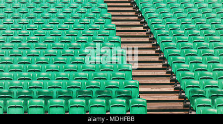 Righe di verde vuoto stadio di piegatura dei sedili e scale in legno Foto Stock