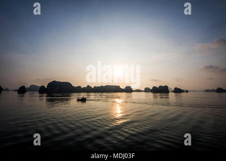 Pietre calcaree carsiche e le isole della baia di Ha Long al tramonto; Quang Ninh, Vietnam Foto Stock