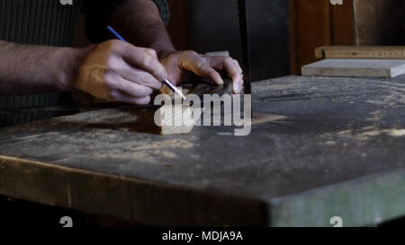 Carpenter misure e segna la linea di taglio utilizzando un falegname righello Foto Stock