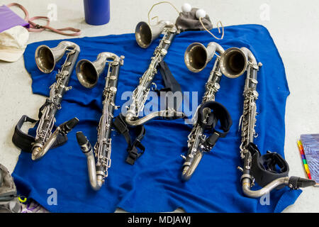 Diversi clarinetti bassi in appoggio su una coperta durante la prova Foto Stock