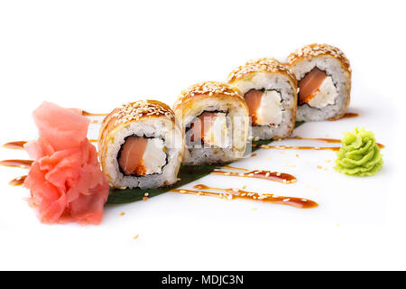 Appetitoso e originale rotoli di sushi con salmone affumicato e formaggio Filadelfia in una frittata steso su una foglia di banano. Isolato. Rotolo di sushi su un whi Foto Stock