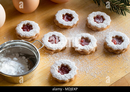 Linzer tradizionali biscotti di Natale spolverato con zucchero su un tavolo Foto Stock