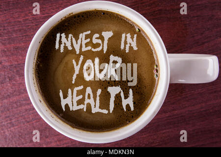 La scrittura della nota mostra investire nella vostra salute. Business photo vetrina per spendere soldi in personal healthcare prove preventive scritto il caffè nella tazza bianca Foto Stock