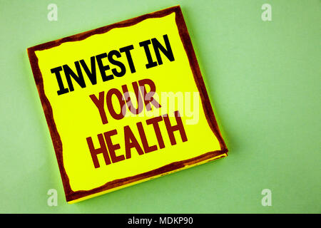 La scrittura della nota mostra investire nella vostra salute. Business photo vetrina per spendere soldi in personal healthcare prove preventive scritte bigliettino giallo Foto Stock