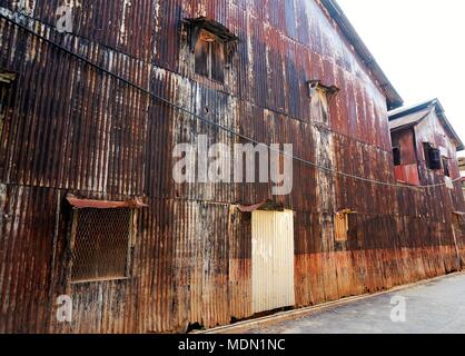 Il vecchio muro di zinco e zinco arrugginito sul muro di mattoni rossi recinto per background e texture. Foto Stock