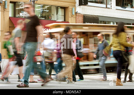 San Francisco, CA, Stati Uniti d'America - 17 Ottobre 2014: le persone che attraversano la strada e un trolley car motion blur lungo Powell Street di San Francisco. Foto Stock