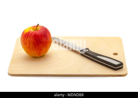 Ripe Rosso mela succosa e coltello su un tagliere realizzato in legno chiaro. Foto Stock