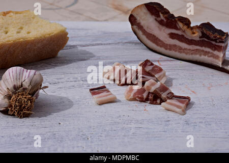 Delizioso piatto con pancetta affumicata, aglio e pane a rustico sfondo legno/ tradizionale cibo dei Balcani Foto Stock