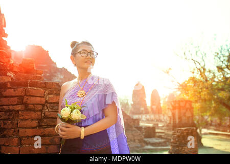 Donna thai toothy volto sorridente in piedi con rosa lotus mazzo di fiori in mano Foto Stock