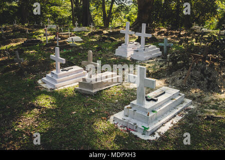 Vecchia tomba il tradizionale cimitero europeo in Slovacchia. Età croce di pietra tombale sulla tomba cantiere in primavera. cimitero nel bosco Foto Stock