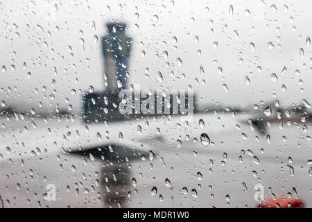 Viste della Santiago de Compostela - aeroporto Lavacolla il traffico aereo della torre di controllo in un giorno di pioggia, attraverso un finestrino per aerei coperti con gocce di pioggia Foto Stock