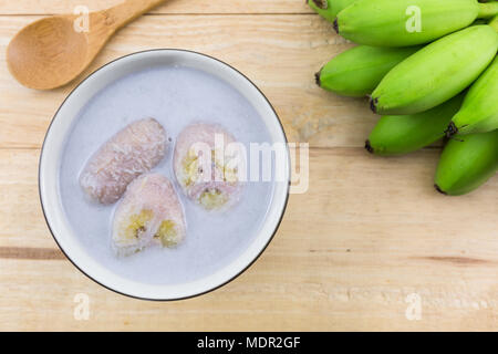 Banana in latte di cocco (Kluay Buad Chee) sulla scrivania di legno, Tailandese deserto. Foto Stock