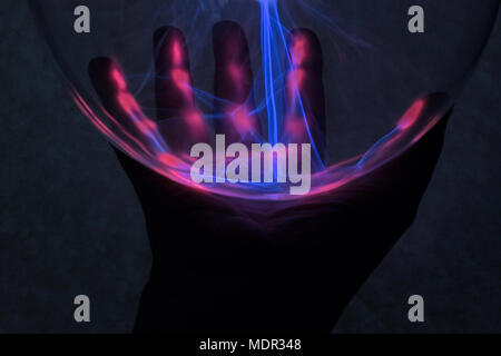 In fondo è la mano che è stata illuminata da plasma dalla lampada al plasma. Foto Stock