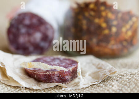 Fetta di salame caldo con schiacciato il peperoncino su uno sfondo Foto Stock