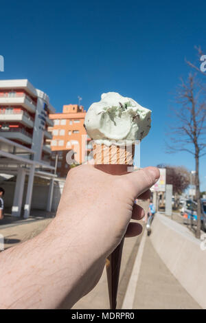 Un maschio di mano che tiene un gelato al di fuori di Santa Susanna, Spagna. Foto Stock