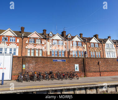 Portabiciclette con parcheggiato pendolari' bici sulla stazione di Woking, Surrey, Regno Unito nel cuore della cinghia di " commuters " in una giornata di sole con cielo blu Foto Stock