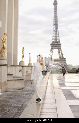 Ragazza camminare sulla piazza del Trocadero vicino a statue dorate e la Torre Eiffel. Foto Stock