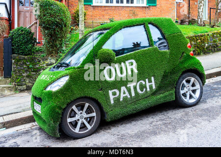 Greene & Co agenti immobiliari di Smart Car avvolta nel verde erba artificiale, con lo slogan "I nostri Patch', Muswell Hill, London REGNO UNITO Foto Stock