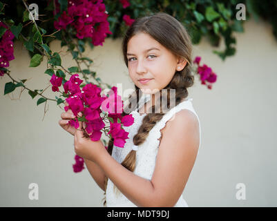 Ritratto di una bambina con fiori nel parco Foto Stock